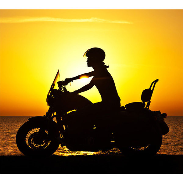 Obraz kobieta na motorze o zachodzie słońca